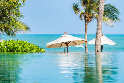 Scenic view of swimming pool by sea against clear sky