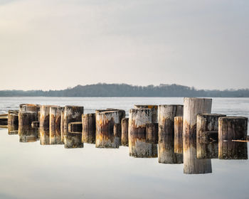 Panoramic view of wooden posts in lake against sky