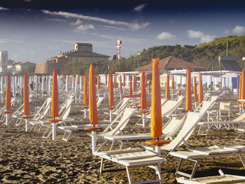 Chairs on beach against sky