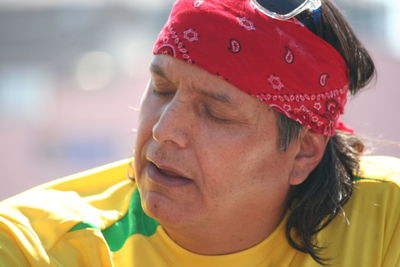 Close-up of mature man wearing red bandana on sunny day