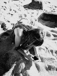 High angle view of woman lying down on sand