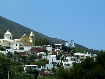 Aircraft over houses against clear sky at aeolian islands