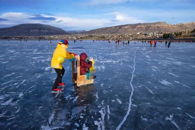 People on snow covered mountain against sky