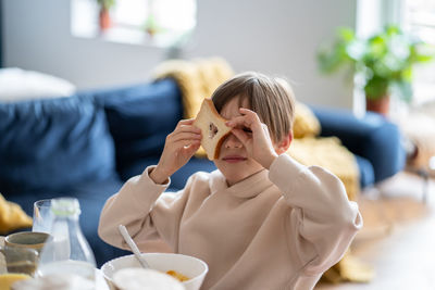 Portrait of girl eating food at home