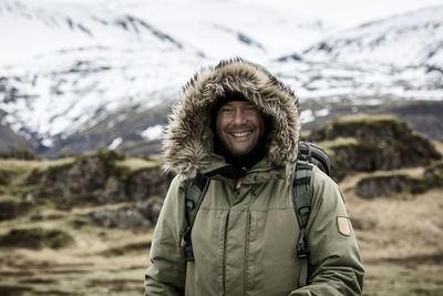 Portrait of man standing on snow covered mountain