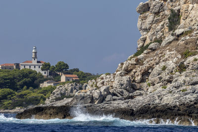 Scenic view of sea by buildings against clear sky