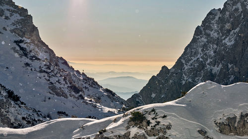 Scenic view of snow covered mountains against sky during sunset