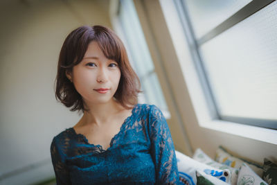 Portrait of a beautiful young woman standing at home