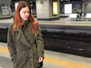 Beautiful woman standing at railroad station platform