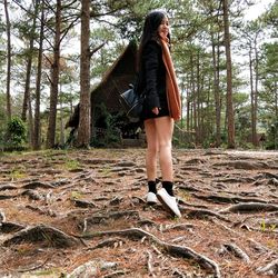 Full length of woman standing in forest