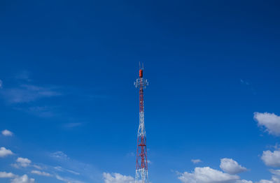 Low angle view of communications tower against blue sky