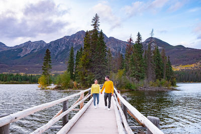 Rear view of people on lake against sky