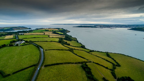 High angle view of landscape by sea against cloudy sky