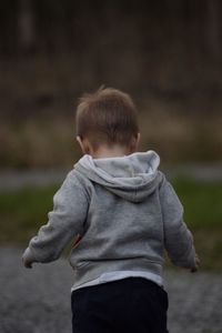 Rear view of boy standing outdoors