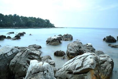 Rocks on sea shore against sky