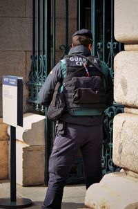 Rear view of man standing by building