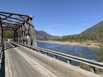 Footbridge over mountains against clear blue sky