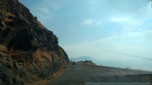 Road leading towards mountain against sky