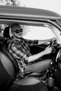 Portrait of young man sitting in car