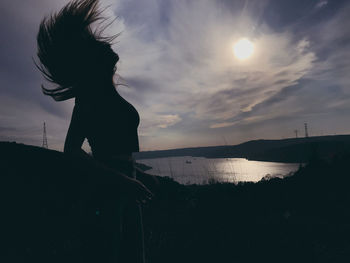 Side view of silhouette woman standing at sunset