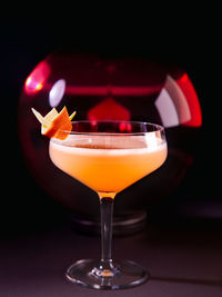 Closeup of hemingway daiquiri cocktail in coupé glass with dark red background