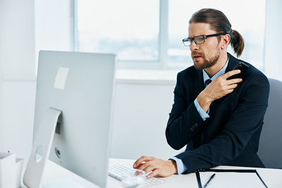 Young man using mobile phone while sitting on table