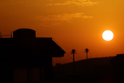 Silhouette built structure against sky during sunset