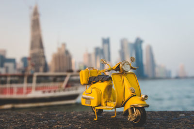 Yellow cart on river against buildings