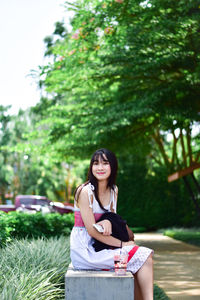 Portrait of smiling young woman sitting outdoors