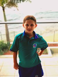 Portrait of boy standing against wall