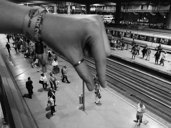 Optical illusion of person holding woman at railroad station platform