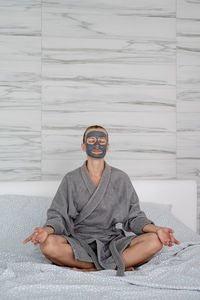 Womens health. spa and wellness. woman with face mask relaxing sitting on the bed