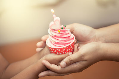 Cropped hands holding cupcake