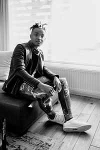 Portrait of young man sitting on floor