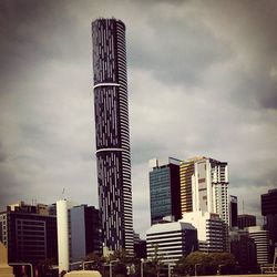 Low angle view of modern building against cloudy sky