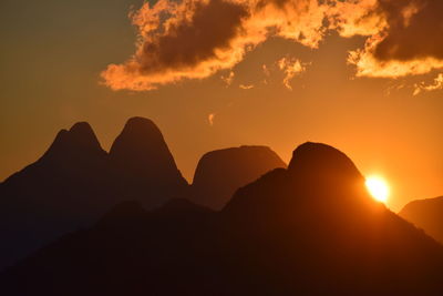 Scenic view of silhouette mountains against romantic sky