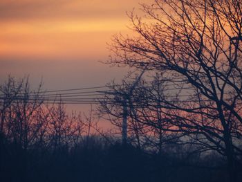 Low angle view of silhouette bare trees against romantic sky