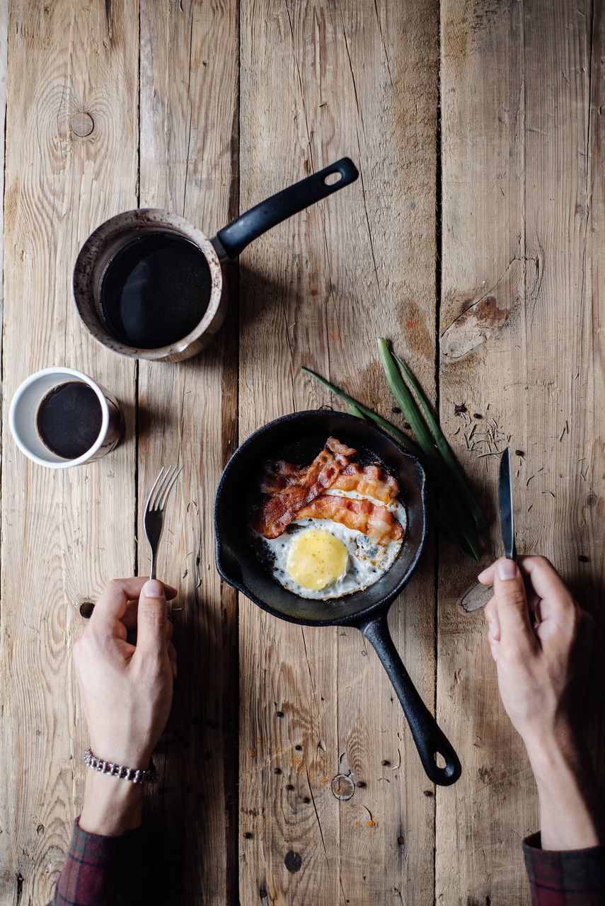 HIGH ANGLE VIEW OF CROPPED HAND HOLDING FOOD