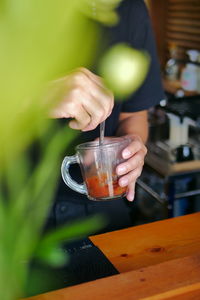 Close-up of hand pouring drink in glass