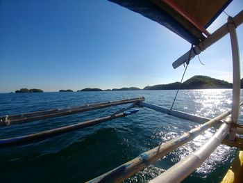 Sailboat sailing in sea against clear blue sky