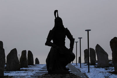 Silhouette statue against clear sky during winter