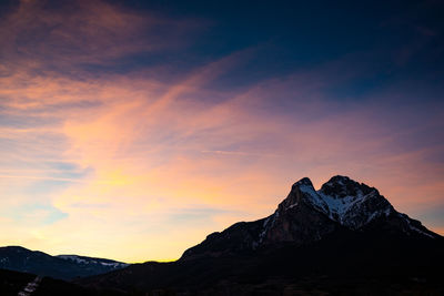 Scenic view of snowcapped mountains against sky during sunset