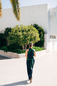 Full length portrait of woman standing against trees