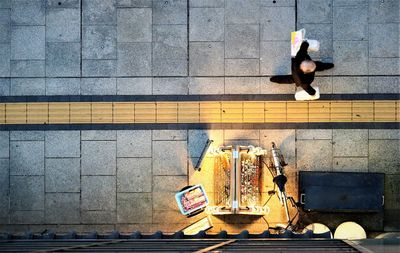 High angle view of man walking on footpath in city