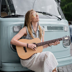 Portrait of a young woman playing guitar