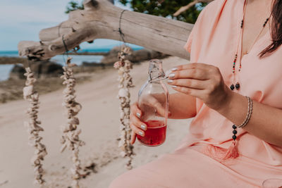 Midsection of woman holding wineglass