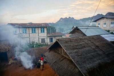 Man outside house against sky