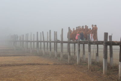 Wooden fence on field against sky