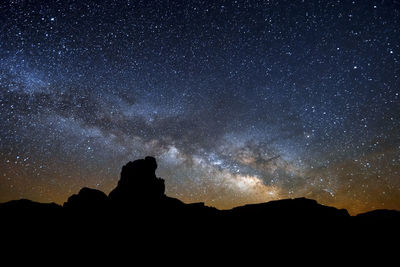 Silhouette mountain against sky at night