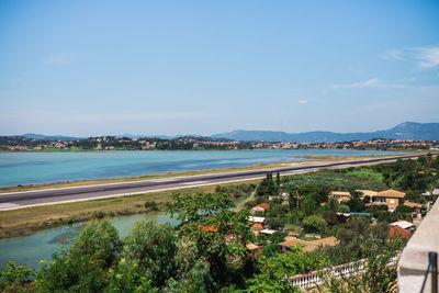 High angle view of city by sea against sky